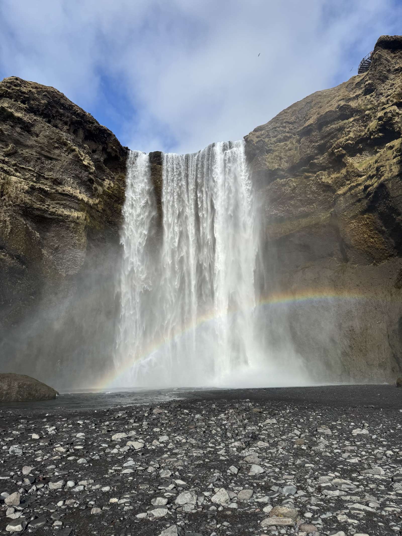 Skógafoss waterfall with a full rainbow, the classic South Coast day trip stop