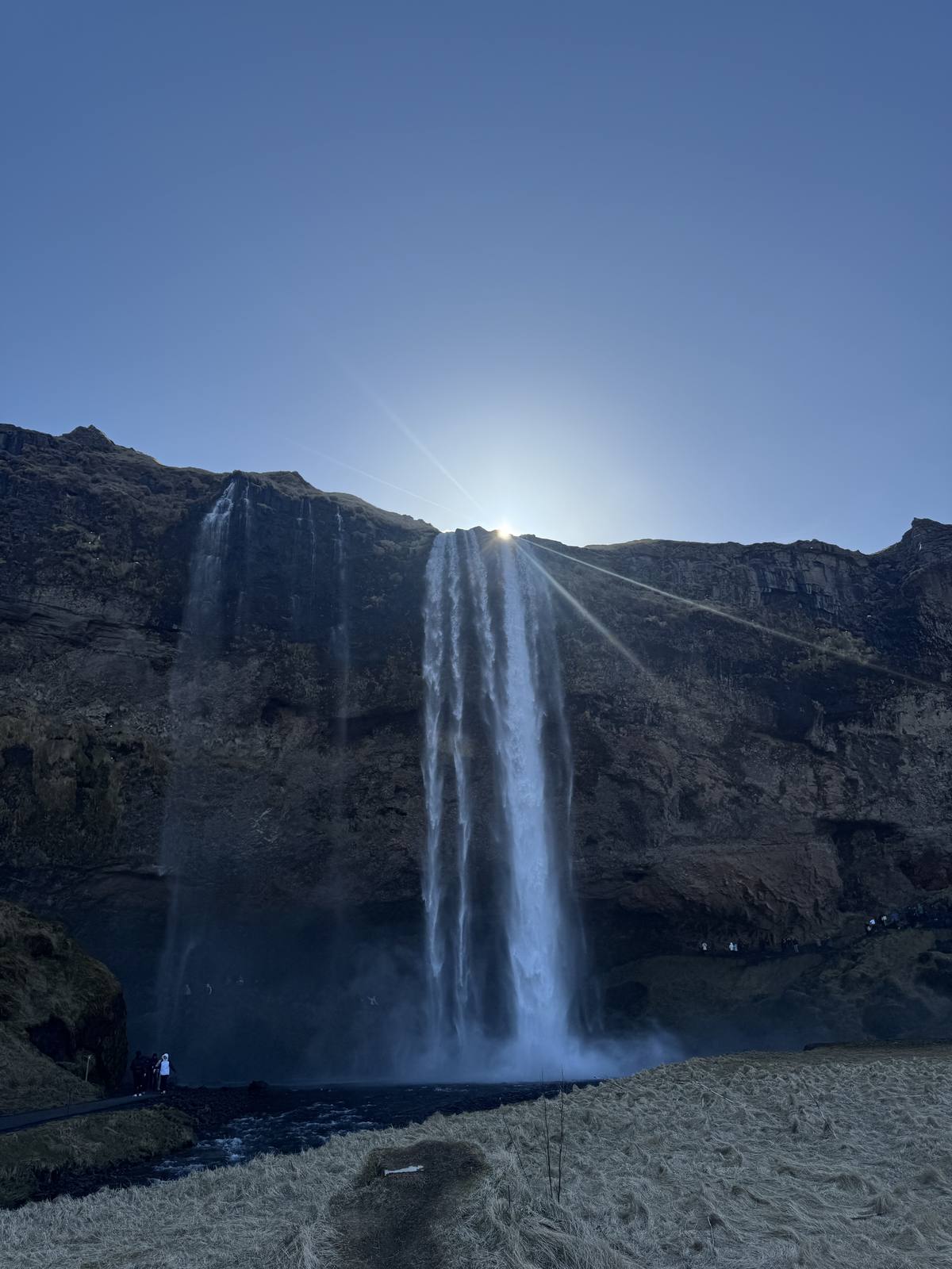 Sun flaring behind the falling water at Seljalandsfoss on Iceland's South Coast