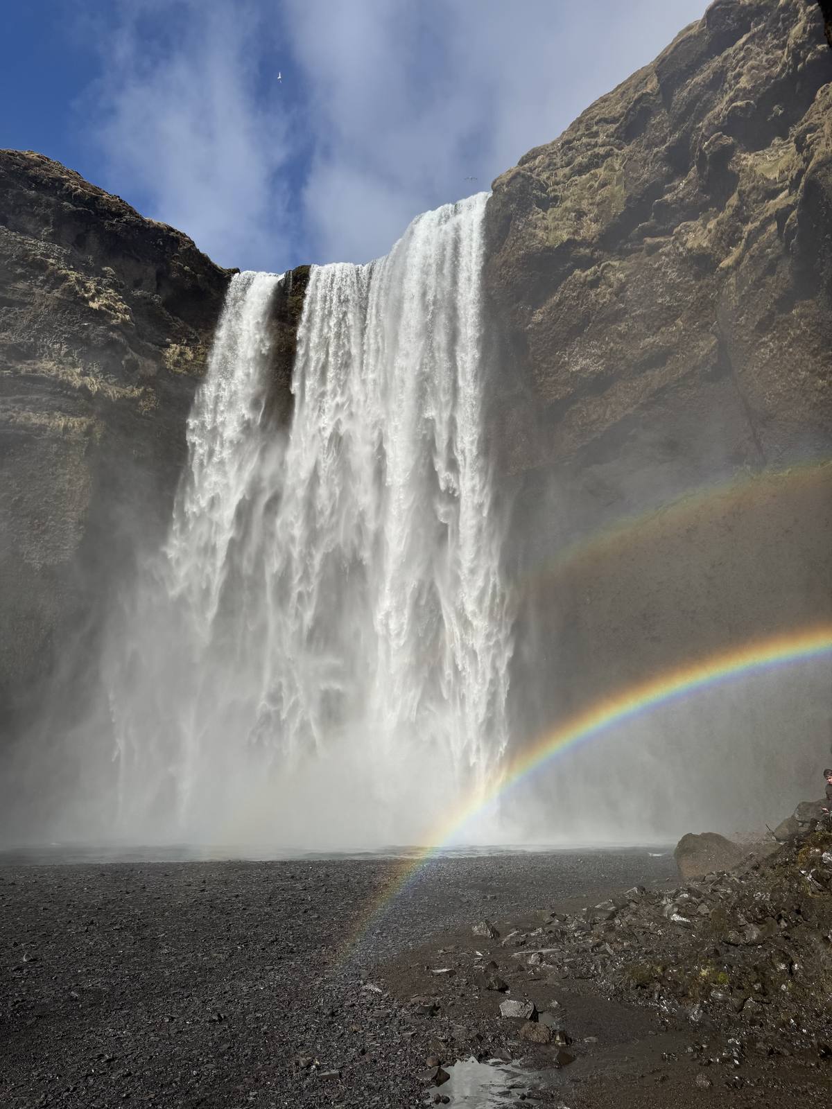 Skógafoss waterfall with a full rainbow arcing across its 60-metre curtain on Iceland's South Coast